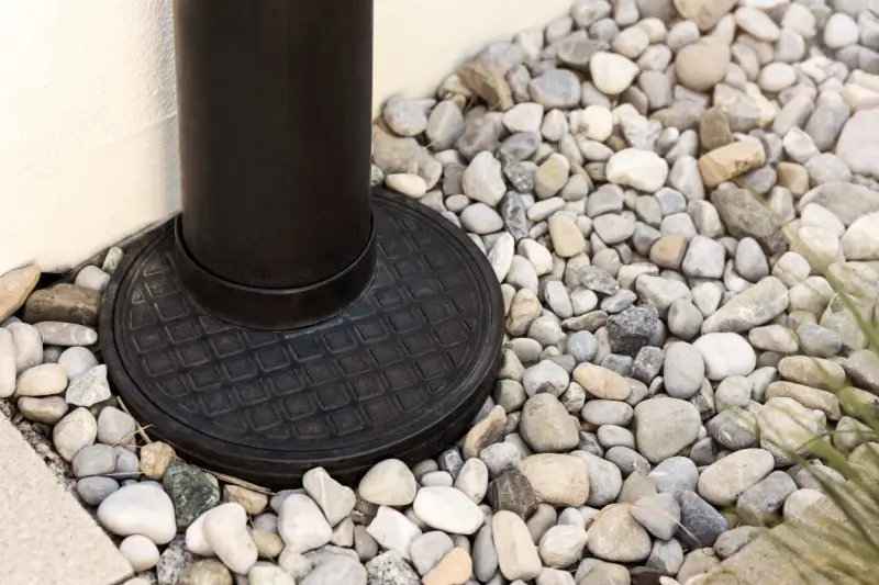 French drain surrounded by river rocks.